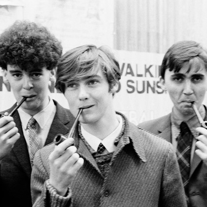 B/w photo of Scottish alt-pop band Aztec Camera, all holding old fashioned pipes, early '80s. 